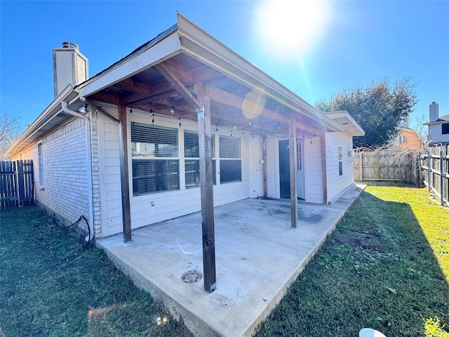 back of house with a yard and a patio