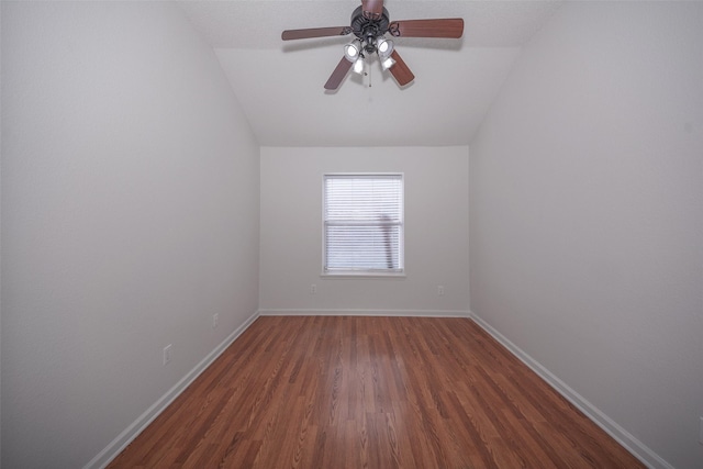 empty room featuring ceiling fan, dark hardwood / wood-style flooring, and lofted ceiling