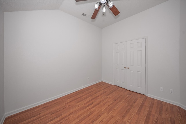 spare room with ceiling fan, wood-type flooring, and lofted ceiling