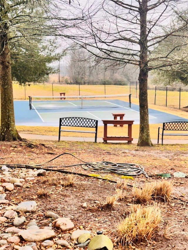 view of home's community with tennis court