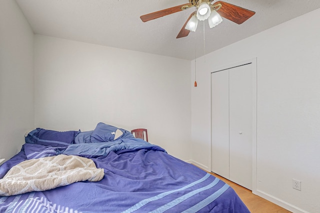 bedroom featuring ceiling fan, a closet, and light hardwood / wood-style flooring