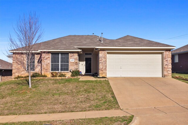 single story home with a garage and a front lawn