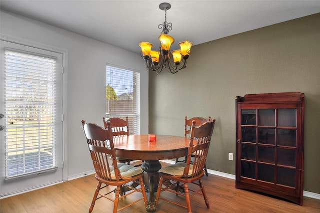 dining room featuring hardwood / wood-style floors and an inviting chandelier