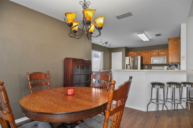 dining area with a notable chandelier and dark hardwood / wood-style floors