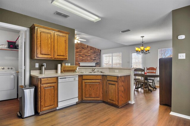 kitchen featuring dishwasher, dark hardwood / wood-style floors, kitchen peninsula, washer / clothes dryer, and ceiling fan with notable chandelier