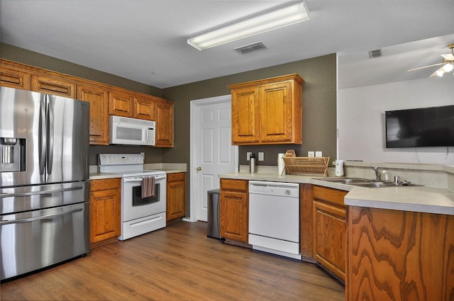 kitchen featuring ceiling fan, sink, dark hardwood / wood-style floors, and white appliances