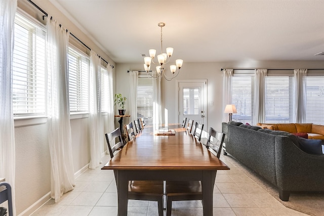 tiled dining room featuring an inviting chandelier and a healthy amount of sunlight