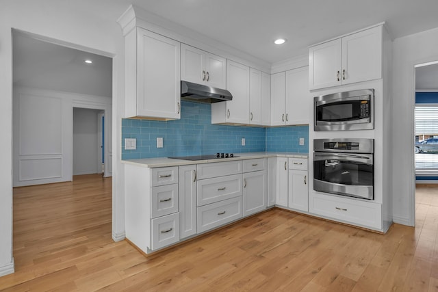 kitchen featuring white cabinets, stainless steel appliances, and light wood-type flooring