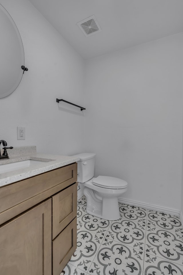 bathroom featuring tile patterned floors, vanity, and toilet