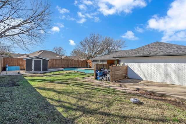 view of yard featuring a fenced in pool and a storage unit