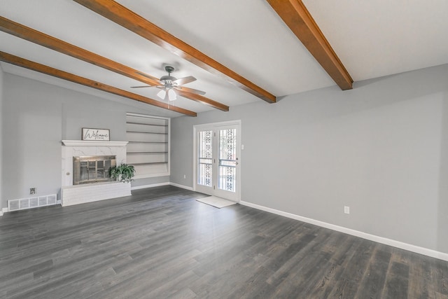 unfurnished living room with beam ceiling, dark wood-type flooring, a high end fireplace, and ceiling fan