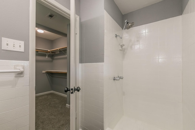 bathroom featuring tile walls and tiled shower