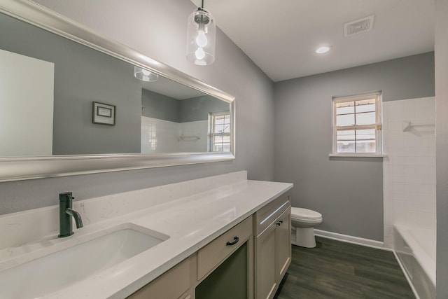 full bathroom with hardwood / wood-style floors, vanity, a wealth of natural light, and toilet