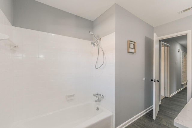 bathroom with shower / bathtub combination and hardwood / wood-style floors