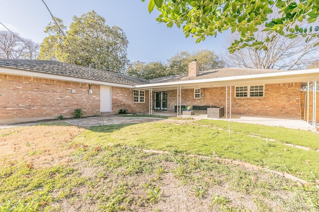 rear view of house with an outdoor living space, a yard, a patio area, and central AC unit