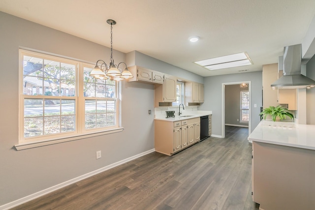 kitchen with sink, dark hardwood / wood-style floors, black dishwasher, decorative light fixtures, and wall chimney exhaust hood