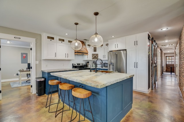 405 Hubbard, Josephine, TX 75173 - kitchen featuring pendant lighting, a kitchen island with sink, stainless steel appliances, white cabinets, and a barn door
