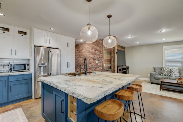 405 Hubbard, Josephine, TX 75173 - kitchen with appliances with stainless steel finishes, a kitchen island with sink, hanging light fixtures, white cabinets, and blue cabinets