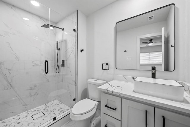 bathroom featuring vanity, toilet, walk in shower, and ceiling fan