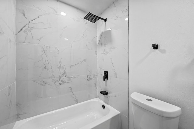 bathroom with tiled shower / bath combo and toilet