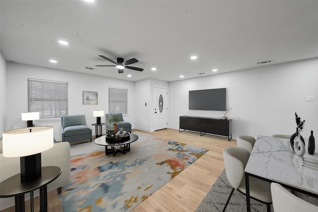 living room featuring ceiling fan and light hardwood / wood-style floors