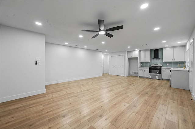 unfurnished living room with ceiling fan, light hardwood / wood-style floors, and sink