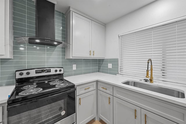 kitchen featuring white cabinetry, sink, wall chimney range hood, tasteful backsplash, and stainless steel range with electric cooktop