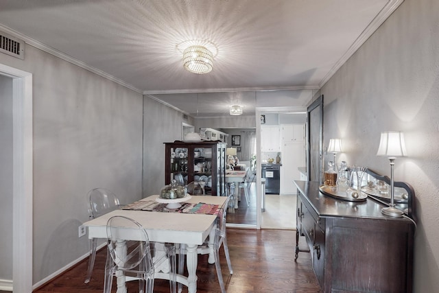 dining room with dark wood-type flooring, a chandelier, and ornamental molding