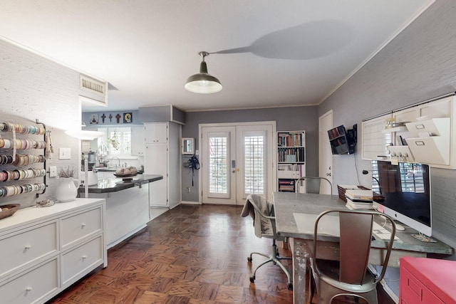 dining area with dark parquet floors, ornamental molding, sink, and french doors