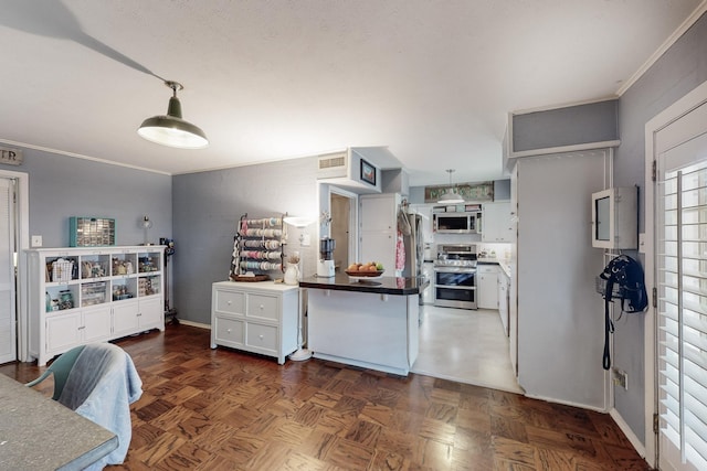 kitchen with dark parquet floors, stainless steel appliances, white cabinetry, and hanging light fixtures