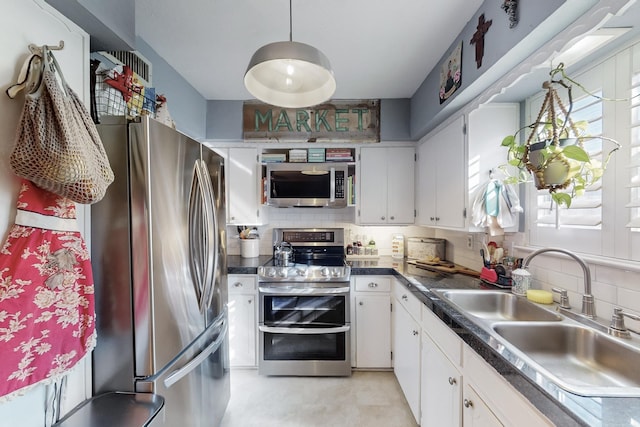 kitchen featuring decorative backsplash, appliances with stainless steel finishes, white cabinetry, and sink