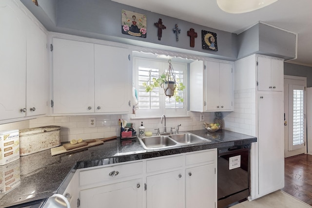 kitchen with dishwasher, backsplash, white cabinetry, and sink