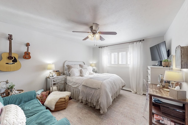 bedroom with a textured ceiling, light colored carpet, and ceiling fan