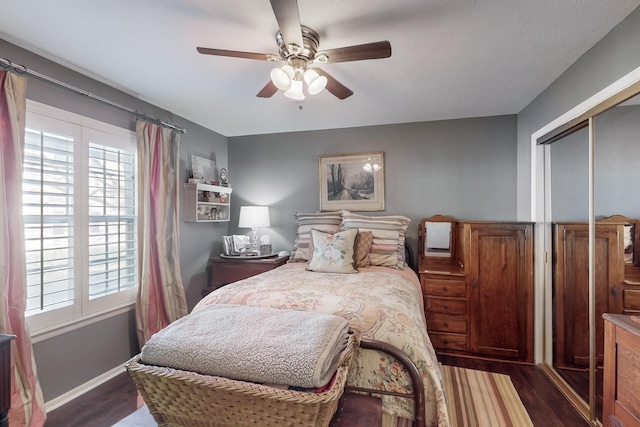 bedroom featuring ceiling fan, dark wood-type flooring, and a closet