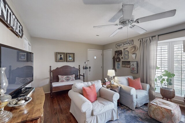 living room featuring ceiling fan and dark wood-type flooring