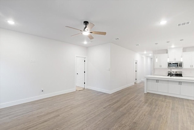 unfurnished living room with ceiling fan and light wood-type flooring