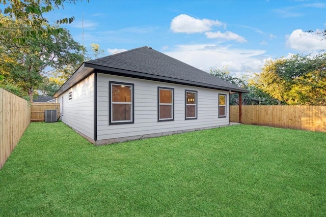 back of house with a yard and central AC