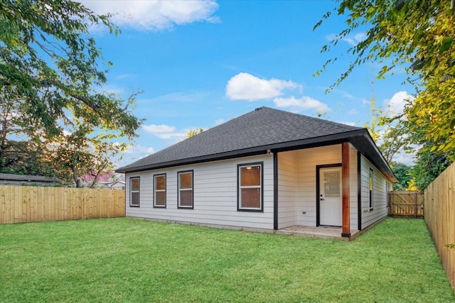 back of house with a lawn