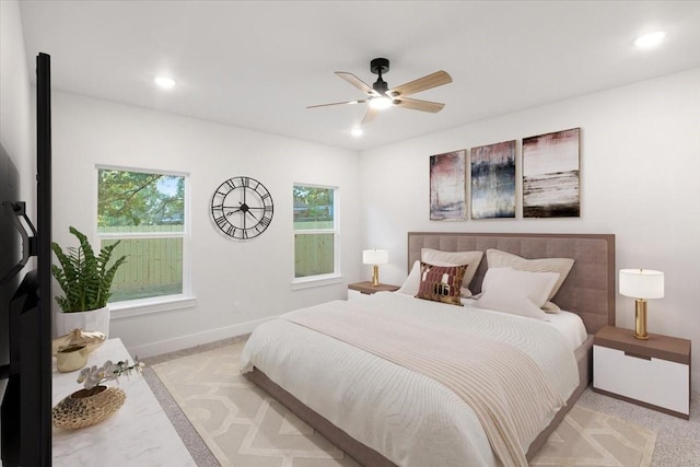 carpeted bedroom featuring ceiling fan and multiple windows