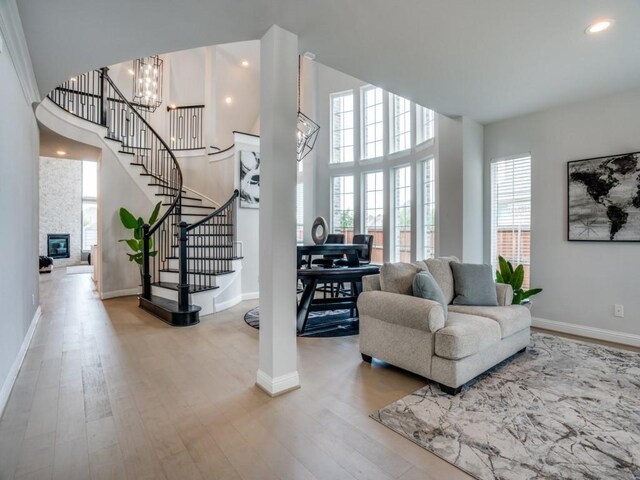 living room with a chandelier, a fireplace, and light hardwood / wood-style floors