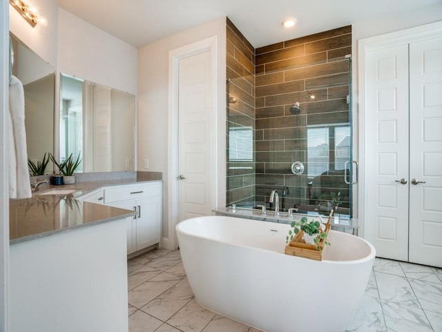 bathroom featuring vanity and shower with separate bathtub