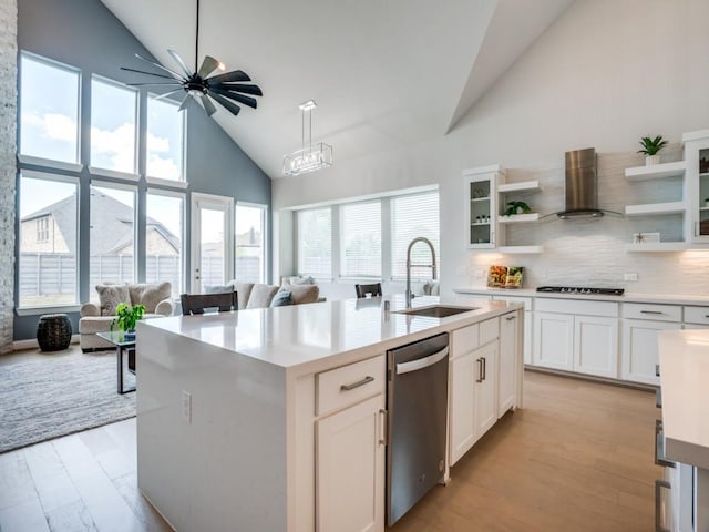 kitchen featuring white cabinets, sink, a kitchen island with sink, and exhaust hood