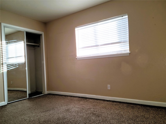 unfurnished bedroom featuring multiple windows, a closet, and carpet floors