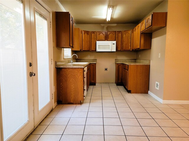 kitchen with light tile patterned floors and sink