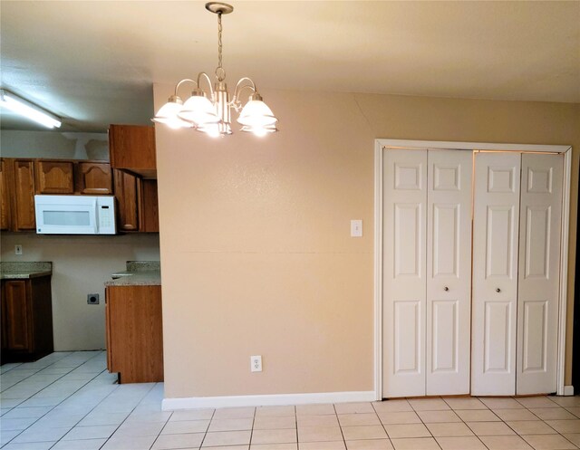 kitchen featuring a chandelier, light tile patterned floors, and decorative light fixtures