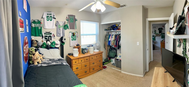 bedroom featuring a closet, light colored carpet, and ceiling fan