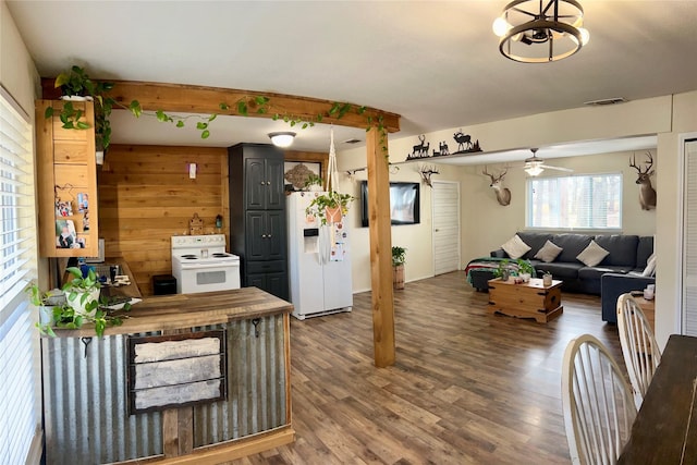 living room featuring wood-type flooring, ceiling fan, and wood walls