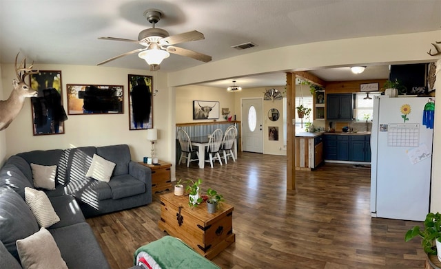 living room featuring ceiling fan and dark wood-type flooring