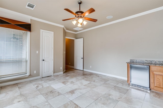 interior space with ornamental molding, ceiling fan, and refrigerator