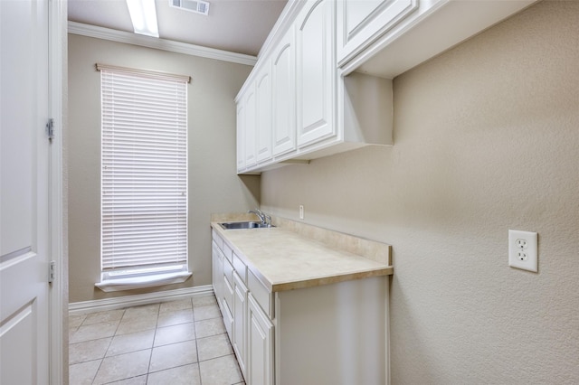 laundry room with sink, light tile patterned floors, and ornamental molding